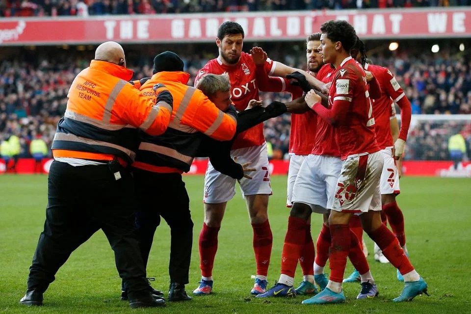 MENGANCAM KESELAMATAN PEMAIN: Seorang penyokong Leicester ditangkap pegawai keselamatan selepas memasuki padang. - Foto REUTERS