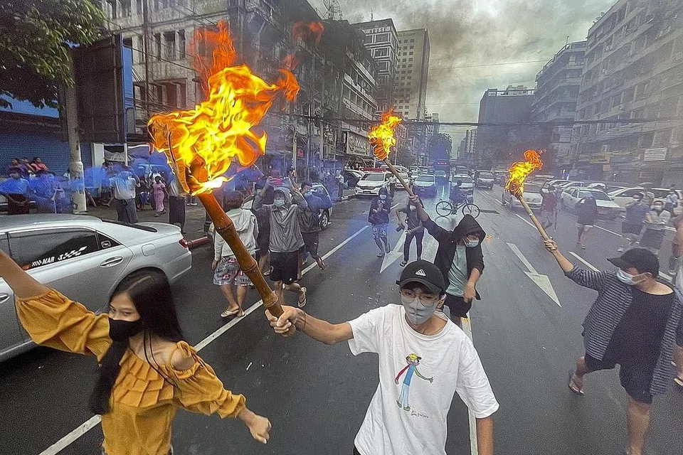 HURU-HARA: Penunjuk perasaan membawa obor semasa bantahan rampasan kuasa anti tentera di kawasan bandar Yangon di Myanmar Sabtu lalu. - Foto EPA-EFE