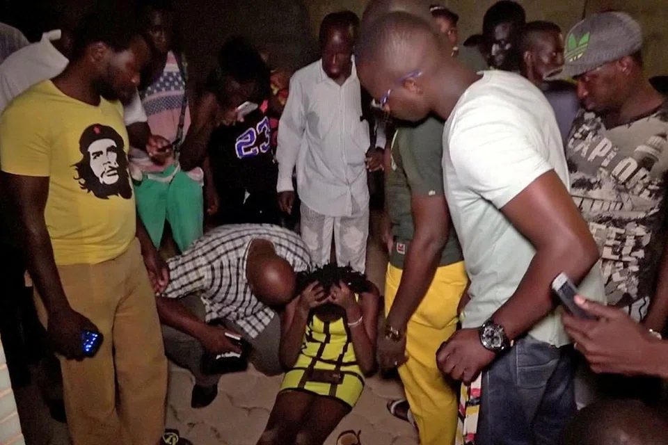 CEDERA: Seorang pelanggan restoran yang cedera, terduduk di lantai sedang orang ramai cuba membantunya selepas serangan oleh beberapa orang bersenjata di restoran di Ouagadougou, Burkina Faso. - Foto REUTERS