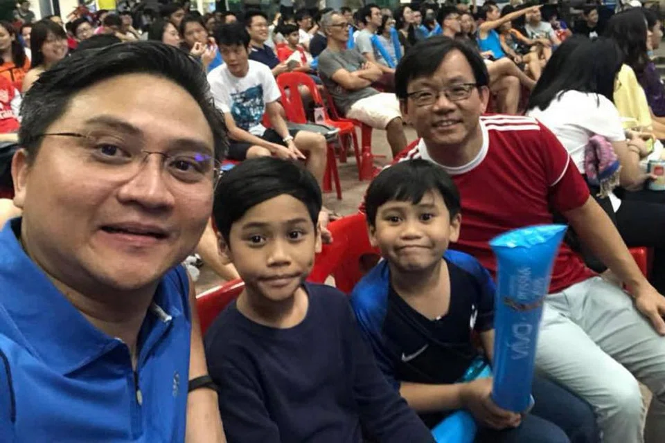 BERSAMA TEMAN: Anggota Parlimen GRC Bishan-Toa Payoh, Encik Saktiandi Supaat (kiri) dan Encik Chong Kee Hiong (baju merah), menyertai ratusan penduduk Bishan dan Toa Payoh di Kelab Masyarakat Bishan bagi menonton perlawanan Piala Dunia antara Perancis dengan Croatia. 