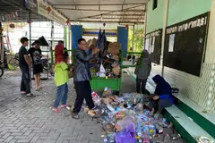 Pentadbir Masjid Al Muharram, Encik Ananto Isworo (tengah), mengeluarkan bahan buangan daripada troli selepas dibawa ke masjid dengan muatan hasil sumbangan penduduk. 
