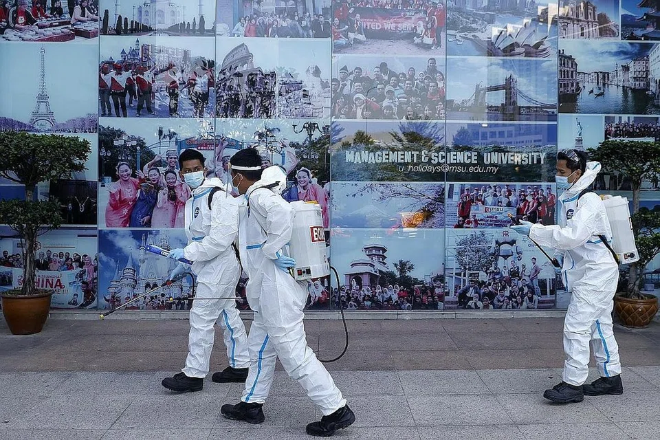 SANITASI: Pegawai Jabatan Bomba dan Penyelamat Melaysia menyahjangkitkan bangunan Universiti Pengurusan dan Sains di Shah Alam, luar Kuala Lumpur Jumaat lalu. - Foto EPA-EFE