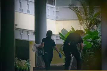 SIASATAN SEDANG DIJALANKAN: Dua pegawai polis kelihatan sedang membawa kotak-kotak bukti di Sekolah Tinggi River Valley semalam - Foto-foto BH oleh MARK CHEONG 