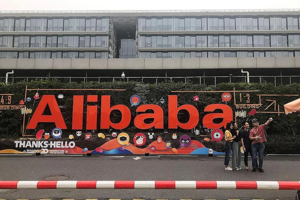 (Gambar atas) pula menunjukkan orang ramai mengambil gambar di depan ibu pejabat Alibaba di Hangzhou, China. - Foto AFP
