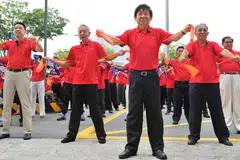 SENAM BERAMAI-RAMAI: Sebagai sebahagian upacara menyambut Hari Kebangsaan oleh ComfortDelGro, 1,220 kakitangan dan pemandu teksinya memecahkan Buku Rekod Singapura dengan senaman beramai-ramai. - Foto THE STRAITS TIMES