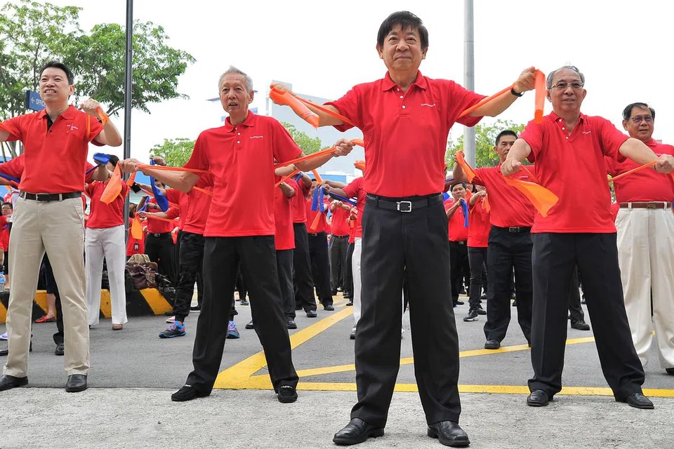 SENAM BERAMAI-RAMAI: Sebagai sebahagian upacara menyambut Hari Kebangsaan oleh ComfortDelGro, 1,220 kakitangan dan pemandu teksinya memecahkan Buku Rekod Singapura dengan senaman beramai-ramai. - Foto THE STRAITS TIMES