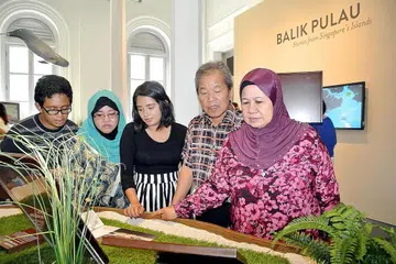 PEMERGIAN SEORANG BIDUAN: Allahyarham Sugiman Jahuri (dua dari kanan) yang terkenal dengan lagu Kisah Cinta kelihatan bersama isteri, Cik Annah Sarip (kanan) dan anak, Cik Roselimnah Sugiman (dua dari kiri) dan dua cucu mereka, Md Syafiq Saat dan Nur Farhana Saat dirakam mengunjungi pameran Balik Pulau: Kisah dari Pulau-Pulau Singapura, di Muzium Negara pada 10 Jun 2014. Kunjungan itu amat bermakna buat mereka memandangkan mereka merupakan bekas penduduk Pulau Bukom Besar. - Foto fail