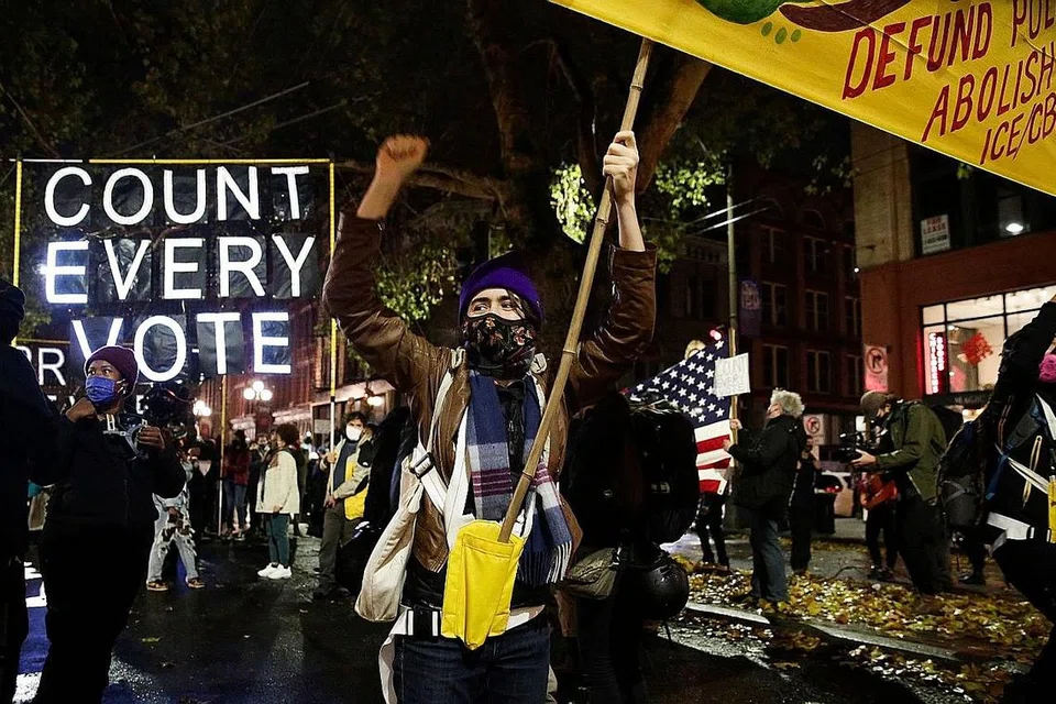 BANTAHAN: Penunjuk perasaan melakukan bantahan damai di Seattle, Washington, sambil menyeru agar setiap undi bagi pilihan raya presiden negara itu dikira. - Foto AFP