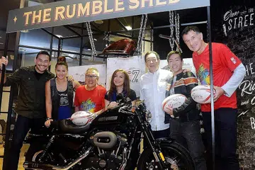 HADIAH MENARIK MENANTI PEMENANG BERTUAH: Encik Low (tiga dari kiri) dan Encik Teo (tiga dari kanan) bersama beberapa selebriti undangan bergambar bersama motosikal Harley-Davidson Roadster yang menjadi hadiah cabutan bertuah untuk acara Ragbi Tujuh Sepasuk HSBC Singapura. - Foto KHALID BABA