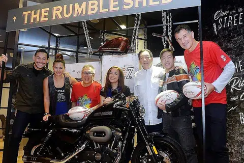HADIAH MENARIK MENANTI PEMENANG BERTUAH: Encik Low (tiga dari kiri) dan Encik Teo (tiga dari kanan) bersama beberapa selebriti undangan bergambar bersama motosikal Harley-Davidson Roadster yang menjadi hadiah cabutan bertuah untuk acara Ragbi Tujuh Sepasuk HSBC Singapura. - Foto KHALID BABA