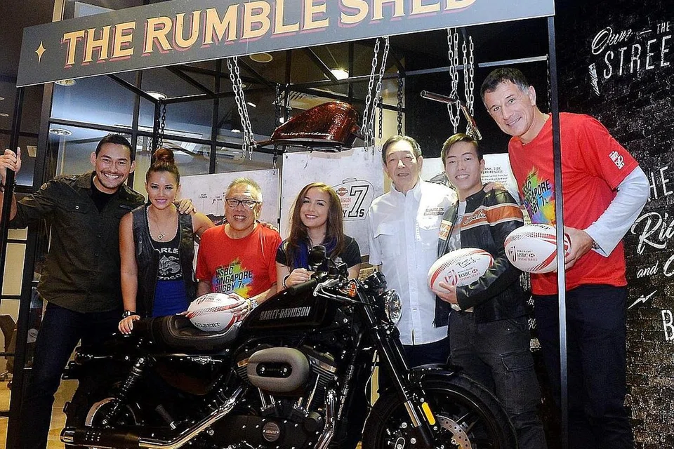 HADIAH MENARIK MENANTI PEMENANG BERTUAH: Encik Low (tiga dari kiri) dan Encik Teo (tiga dari kanan) bersama beberapa selebriti undangan bergambar bersama motosikal Harley-Davidson Roadster yang menjadi hadiah cabutan bertuah untuk acara Ragbi Tujuh Sepasuk HSBC Singapura. - Foto KHALID BABA