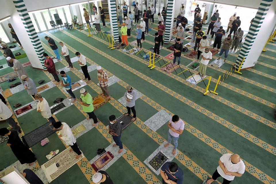 PATUH JARAK SELAMAT: Jemaah menunaikan solat Jumaat di Masjid Al Muttaqin di Ang Mo Kio semalam. - Foto BH oleh GAVIN FOO