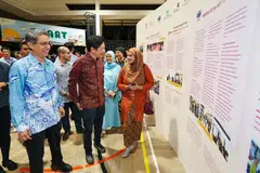 Perdana Menteri, Encik Lawrence Wong (depan, dua dari kiri); dan Pemangku Menteri Bertanggungjawab bagi Ehwal Masyarakat Islam merangkap Menteri Negara Kanan (Ehwal Dalam Negeri), Profesor Madya Dr Muhammad Faishal Ibrahim (depan, kiri) diberi taklimat oleh Naib Presiden II Persatuan Pemudi Islam Singapura (PPIS), Cik Nur Khairah Abdul Rahim (kanan), semasa sambutan ulang tahun ke-60 Singapura ‘SG60 Bersama: Satu Hati, Seribu Bakti’ di Wisma Geylang Serai pada 29 November.