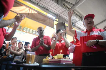 Pengerusi Parti Demokratik Singapura (SDP) dan calon SMC Bukit Panjang, Dr Paul Tambyah (paling kiri), meraikan hari lahir ke-85 pengerusi Parti Kemajuan Singapura (PSP) yang juga calon GRC West Coast-Jurong West, Dr Tan Cheng Bock (paling kanan), bersama anggota PSP lain sebelum sesi lawatan di Pusat Makanan dan Pasar Teban Gardens pada 26 April.