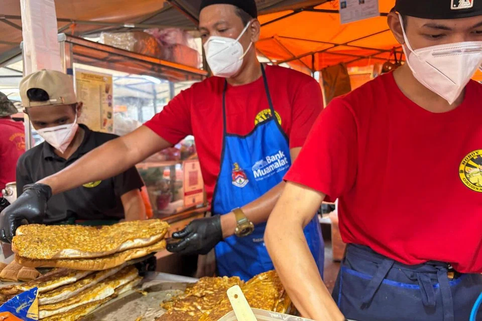 Peniaga martabak, Encik Faizal Mohd Yusop, 44 tahun (tengah), mewajibkan pekerjanya memakai pelitup muka bagi memastikan kebersihan makanan dan mengelak risiko jangkitan TB.