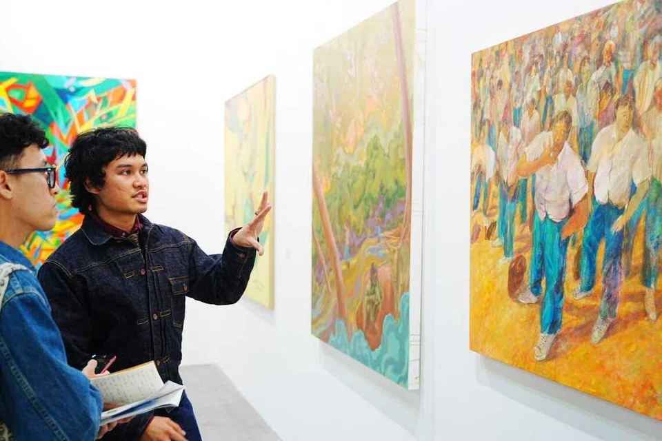 Faris Heizer (kanan) berkongsi kepada penulis bahawa lukisan ‘Morning Assembly, 2025’ adalah sebahagian daripada siri karya terkininya yang menelusuri pemikiran dan ekspresi rumit yang dialami seseorang ketika usia remaja.