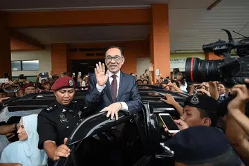 AKHIRNYA DIBEBAS: Datuk Seri Anwar memberi lambaian kepada pihak media dan penyokong yang menunggunya di luar Hospital Rehabilitasi Cheras pada 16 mei lalu. Hospital itu tempat beliau menjalani proses pemulihan selepas satu pembedahan. - Foto AFP