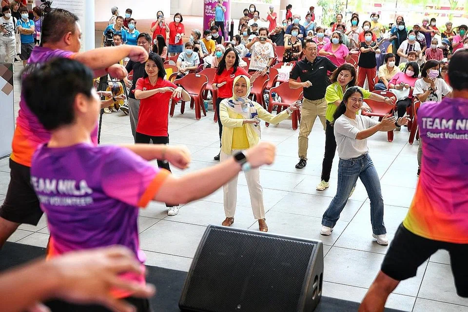TERAPKAN GAYA HIDUP SIHAT: Cik Sun (empat dari kiri) bersama Cik Rahayu (lima dari kiri) menyertai salah satu aktiviti menari semasa Karnival Wanita Sihat, Keluarga Lebih Sihat di One Punggol semalam. - Foto BH oleh FELINE LIM