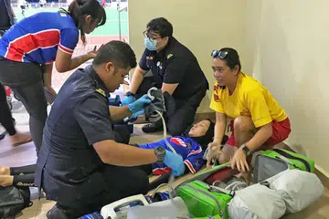 REBAH SEHINGGA HILANG PERGERAKAN: Siti Nur Raihanah (baring) dibantu oleh paramedik selepas rebah ketika bertembung dengan pemain lawan dalam perlawanan Liga Kebangsaan Hoki. - Foto SYAHREENA ZAINUDIN