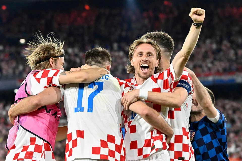 RAIKAN KEJAYAAN: Kapten Croatia, Luka Modric (pertama dari kanan) meraikan kemenangan bersama rakan sepasukan setelah menewaskan Belanda.