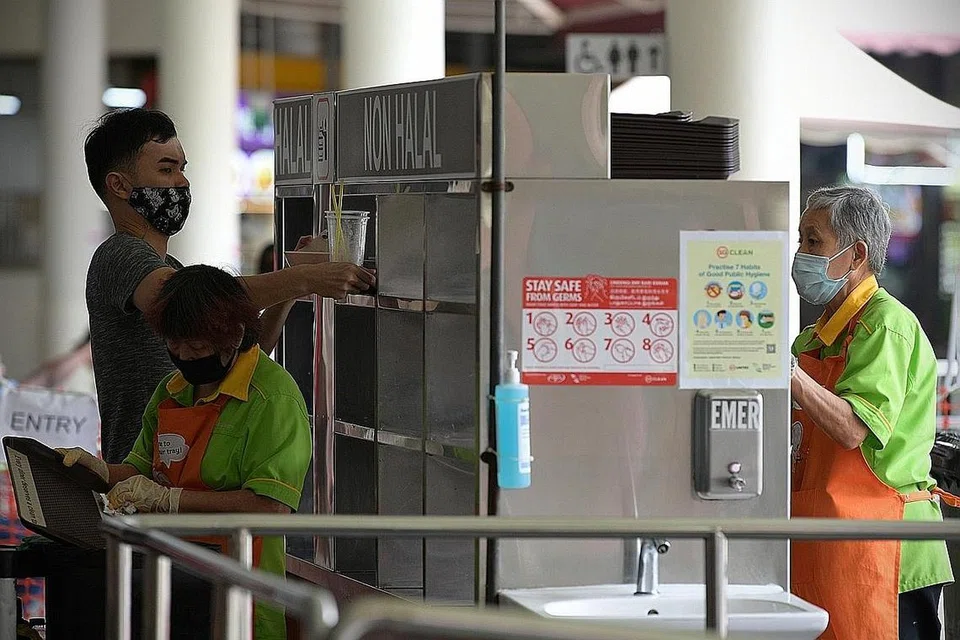 BERSIHKAN MEJA: Pelanggan memulangkan dulang makanan di Pasar dan Pusat Makanan Tiong Bahru September lalu. - Foto BH oleh NG SOR LUAN