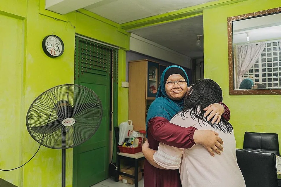 TIDAK MUDAH PUTUS ASAS: Cik Junaidah bersama salah seorang anaknya. Buat ibu tunggal lain, beliau nasihatkan jangan mudah putus asa dan kuatkan diri untuk besarkan anak-anak.