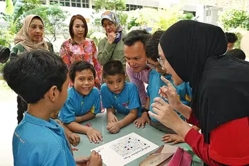 PUSAT BARU: (Dari tiga dari kanan) Encik Zaqy bersama Cik Zuraidah Abdullah, Cik Aidaroyani Adam dan Cik Noorismawaty Sng-Ismail berinteraksi bersama pelajar-pelajar Sekolah Rendah Greendale yang sertai Program Tuisyen Mendaki. - Foto BH oleh KHALID BABA