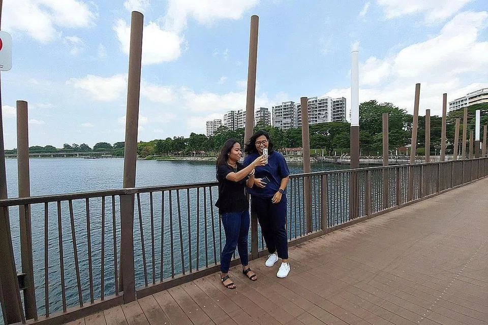 PEMANDANGAN INDAH: Penulis (kiri) dan rakan sekerja, Zulaiqah di Taman Kolam Air Lower Seletar antara tempat yang sesuai untuk seisi keluarga berbasikal, berlari-lari anak, berkayak dan sebagainya. - Foto KHAIRUNNISA RANAM