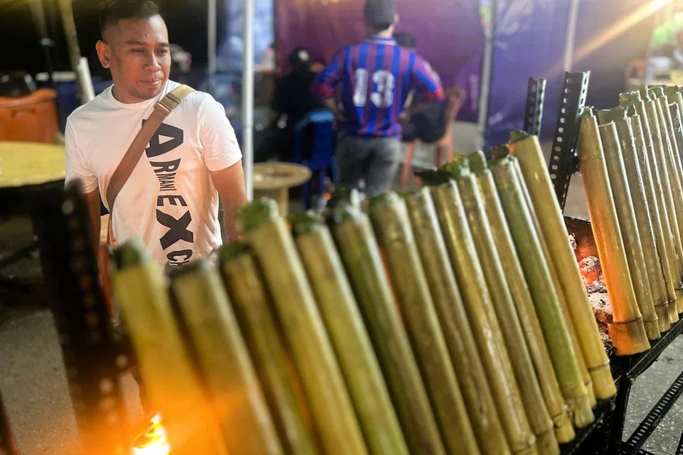 Encik Mohamed Nazri Taib, warga Singapura, melihat pilihan lemang pelbagai saiz yang sedang dibakar.
