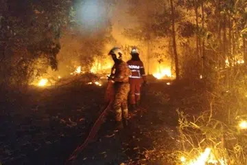 Anggota bomba berusaha memadamkan kebakaran belukar di Taman Permata, Johor Bahru.