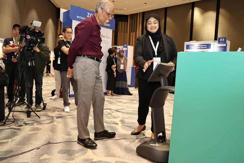 PENGGUNAAN TEKNOLOGI: Penyelia Pusat di Pusat Aktiviti Harian AWWA Ltd, Cik Nur Atiqah, berkongsi dengan Encik Masagos Zulkifli Masagos Mohamad mengenai faedah robot yang dikenali sebagai ‘Temi’ di Sidang Puncak Perkhidmatan Sosial NCSS yang diadakan di Pusat Konvensyen Raffles City.