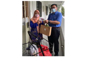SALING MEMBANTU: Presiden True Hearts.sg, Dr Mohamad Yusof Sa'ad (kanan), turut menolong dan memberikan habuan kepada 200 penerima projek 'Jom Sadaqah 2022'. - Foto TRUE HEARTS.SG
