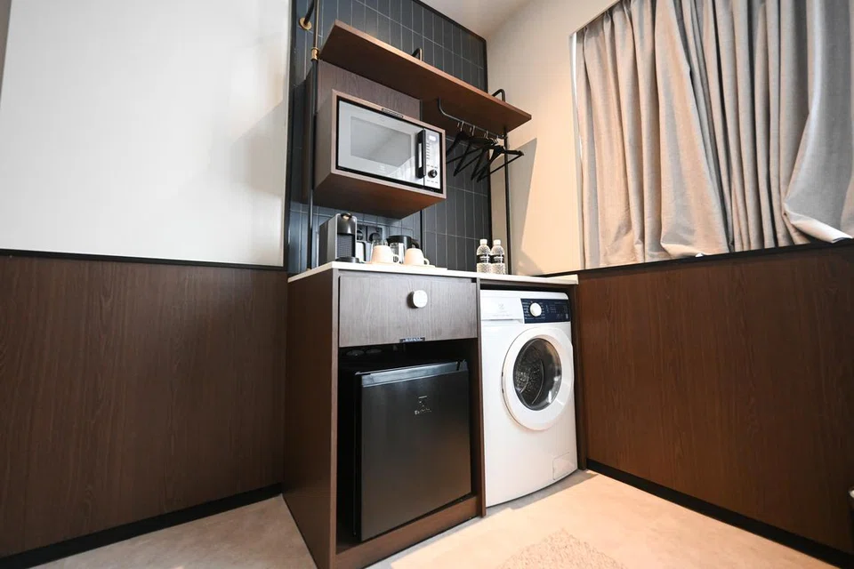 Ruang dapur kecil dilengkapi dengan ketuhar gelombang mikro, peti sejuk mini, mesin basuh dan pengering dan mesin membuat kopi.