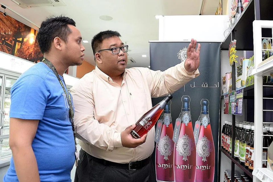 LEBIH FAHAM PRODUK: Encik Muhammad Rizal Mansoor (kanan), bersama seorang pekerja di NikMart Halal Frozen, mendapati kursus Rangka Kerja Kecekapan Kecemerlangan Khidmat meningkatkan lagi pengetahuannya dalam aspek pelayanan. - Foto ZAINAL YAHYA