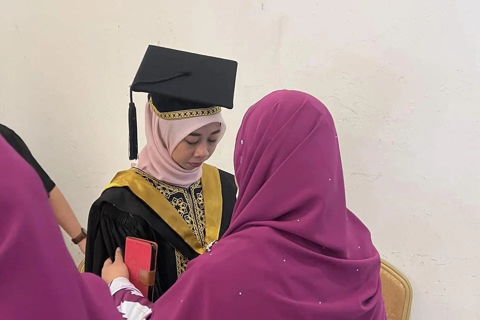 RASA HIBA: Cik Haslina Kalang (kiri) ditenangkan apabila mendapat tahu berita pemergian bapanya, Allahyarham Kalang Tona, semasa Majlis Idul Ilmi Konvokesyen UniSZA ke-15 pada Isnin.