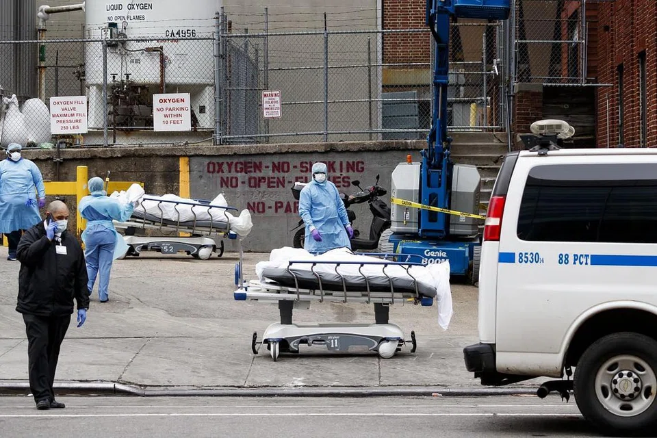 JUMLAH KEMATIAN MENINGKAT: Kakitangan perubatan bersama mayat-mayat yang bakal disimpan buat sementara waktu di rumah mayat mudah alih di luar Pusat Hospital Brooklyn, New York. Rumah mayat mudah alih diperlukan dek kesuntukan tempat di hospital. New York merupakan pusat wabak Covid-19 di AS. - Foto EPA-EFE