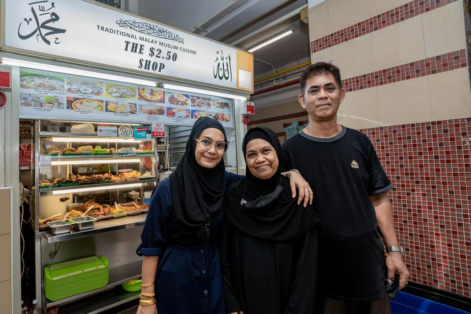 INGIN BANTU GOLONGAN MEMERLUKAN: Cik Hani Isnin bersama ibu bapanya Cik Munah dan Encik Isnin di depan gerai mereka yang terletak di Pusat Makanan Jalan Kukoh.