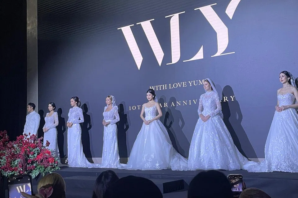 Barisan model memperagakan koleksi gaun putih WLY yang sentiasa menjadi minat pengantin sepanjang zaman.