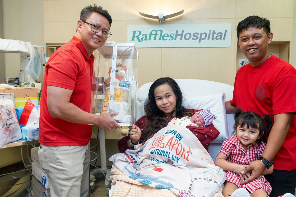 Cik Izzah Syazana Mazlan (dua dari kiri) dan suaminya, Encik Muhammad Faris Rashid (kanan), bersama anak kedua mereka, Muhd Ijaz Azry Muhamad Faris, serta anak sulung, Izara Arissa Muhammad Faris, bergambar bersama doktor yang menyambut kelahiran Ijaz, Dr Jazlan Joosoph (kiri), di Hospital Raffles. Ijaz dilahirkan pada 11.06 pagi Hari Kebangsaan dan merupakan bayi pertama yang dilahirkan di hospital itu pada 9 Ogos.