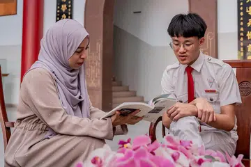 BELAJAR BAHASA MELAYU: Darius Song mula mempelajari Bahasa Melayu sebagai bahasa ketiga ketika dalam menengah satu di Sekolah Tinggi Chung Cheng (Main). Bersamanya ialah gurunya, Cikgu Khairunnisa Yahya. - Foto BH oleh NUR DIYANA TAHA
