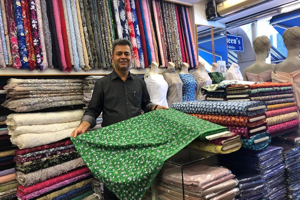 RINDU KEMERIAHAN: Sebelum ini kawasan Arab Street meriah dengan pelanggan yang bersemangat untuk mendapatkan kain-kain khas untuk Hari Raya. Namun, Encik Faslur (atas), yang memiliki kedai Suria Fabrics dan Sharvan's, berkata kemeriahan itu kini berkurang. - Foto BH oleh NATASHA MUSTAFA