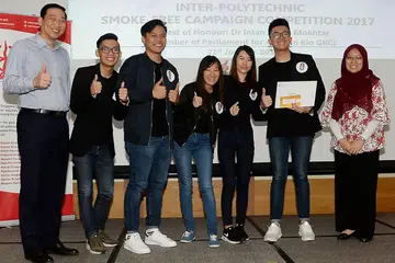 PEMENANG ANUGERAH ULUNG: Dr Intan Azura (kanan) dan Encik Albert Ching (kiri) bersama peserta Politeknik Temasek yang menjadi juara kempen Bebas Merokok antara politeknik di sini. Pasukan pemenang itu menerima hadiah baucar beli-belah bernilai $1,000. - Foto JOHARI RAHMAT