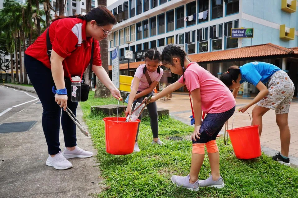 (Dari kiri) Cik Maggie Phua, 36 tahun, dan dua anaknya, Zoey Ong, lapan tahun dan Chloey Ong, enam tahun, telah mengambil bahagian dalam kegiatan mengutip sampah di Toa Payoh pada 28 April.