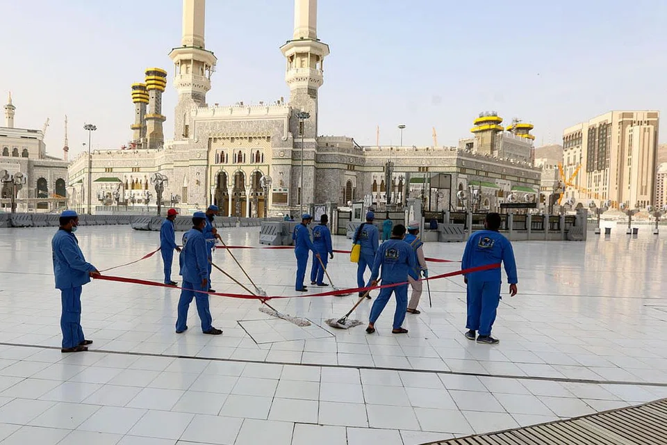 DIBERSIHKAN: Pekerja membersihkan dan membasmi kuman di perkarangan Masjidil Haram, menyusuli keputusan membenarkan semula ibadat umrah secara berperingkat mulai esok. - Foto AFP