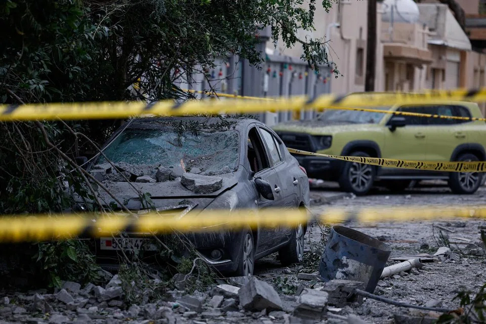 Sebuah kereta remuk berhampiran bangunan yang rosak di lokasi jatuhan serpihan dron, yang menurut Kementerian Dalam Negeri Bahrain berpunca daripada dron Iran yang dipintas pada malam sebelumnya, ketika konflik antara Amerika Syarikat dan Israel dengan Iran, di Sitra, Bahrain, 4 April 2026 