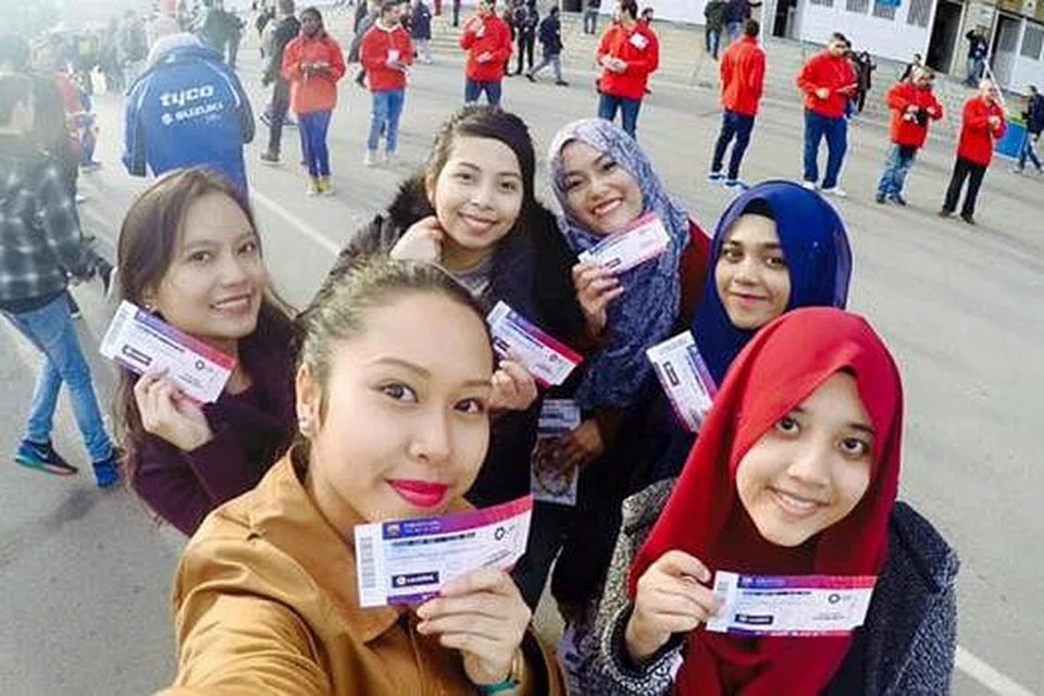 STADIUM NOU CAMP: Penulis (kiri) dan kawan-kawannya mengambil gambar bersama tiket perlawanan sebelum memasuki stadium. Pegawai stadium yang memakai baju berwarna merah memeriksa beg dan jaket bagi memastikan tiada alat berbahaya dibawa masuk. 