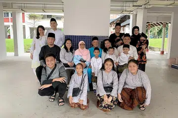 SIFATNYA RIANG: Allahyarham (berbaju biru) meninggal dunia akibat kecederaan yang dialaminya apabila sebuah botol kaca yang dibuang dari flat kondominium 35 tingkat di Spottiswoode Park terkenanya. Beliau meninggalkan isteri, (bertudung merah jambu) Cik Manisah, empat anak - antaranya adalah Cik Suriati (sebelah Cik Manisah) - serta sembilan cucu. - Foto ihsan CIK NAS SURIATI NASIARI