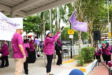 Penasihat perubatan Persatuan Ain, Profesor Fatimah Lateef, mengibarkan bendera sebagai tanda bermulanya acara berjalan kaki World Cancer Walk 2026 di kawasan Haig Walk Extension dekat Haig Road pada 11 Januari.
