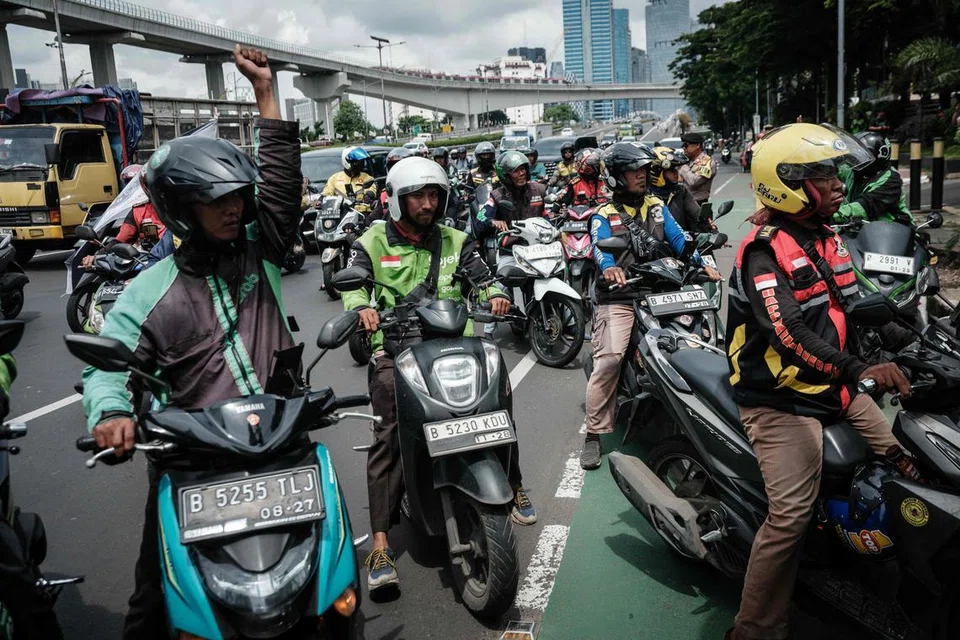 Pemandu teksi motosikal dalam talian  menyertai protes menuntut hak terhadap pemberian elaun hari perayaan  (THR) di hadapan bangunan Kementerian Tenaga Kerja di Jakarta pada 17 Februari 2025. 