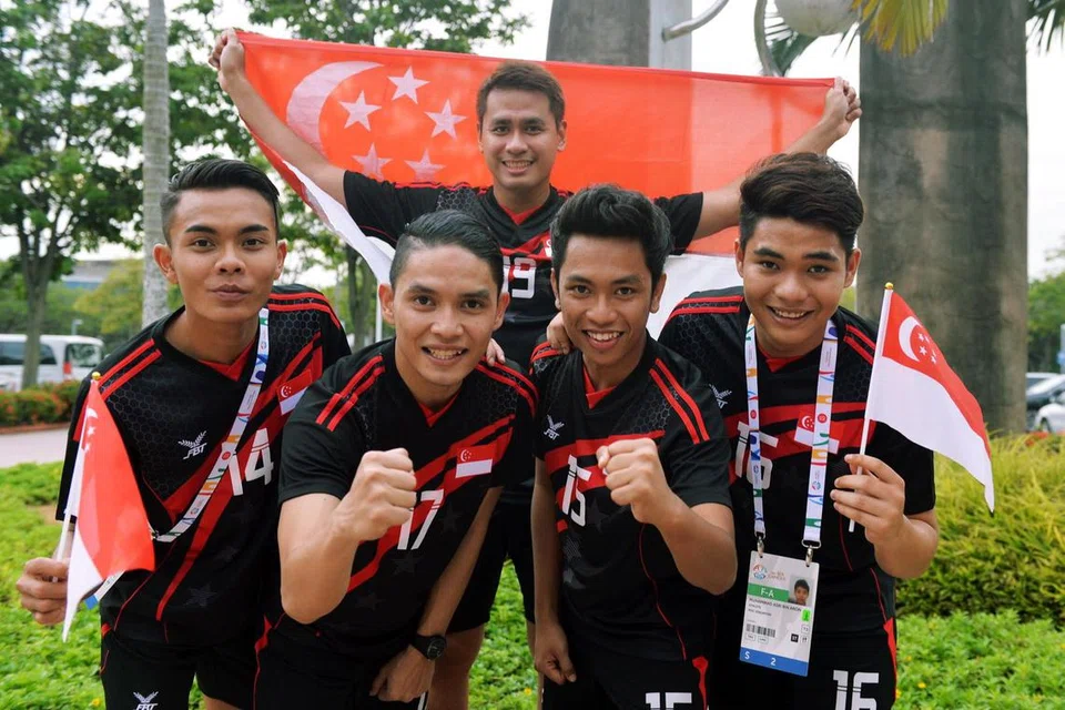 Pemain sepak takraw Singapura (barisan depan dari kiri) Muhammad A’Fif Safiee, Muhammad Hafiz Nor Izam Ja’afar, Muhammad Yassin Suhaimi, Muhammad Asri Aron dan Mohamad Farhan Amran (belakang) yang meraih pingat pertama mereka selepas lebih dua dekad dengan memenangi pingat perak dalam perlawanan akhir regu lelaki di Singapura Expo pada Jun 2015. Mereka menewaskan Filipina dengan keputusan 21-13, 21-11.